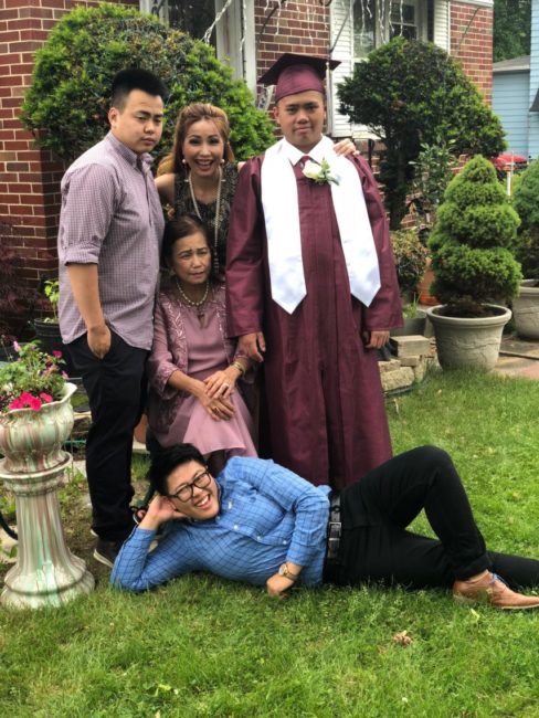 Photo of Jimmy in graduation gown posing with family.