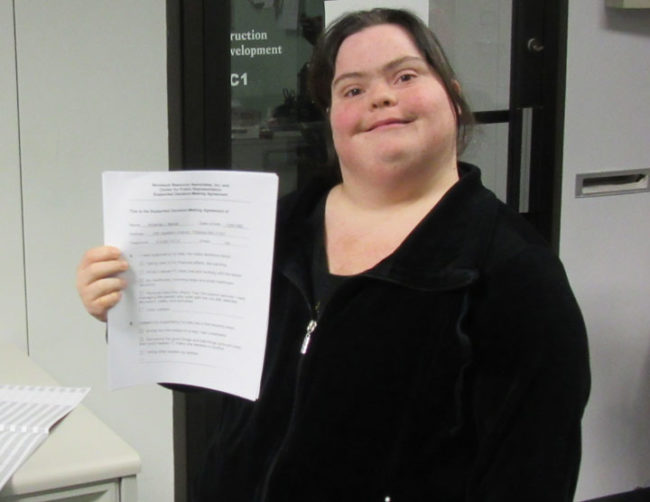 Photo of Amanda holding SDM agreement.